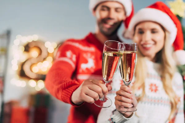 Foco selectivo de pareja tintineo con copas de champán y la celebración de año nuevo - foto de stock