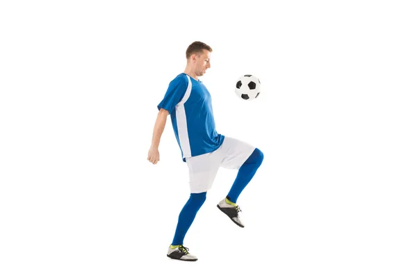 Вид збоку тренування молодого футболіста з м'ячем ізольовано на білому — стокове фото