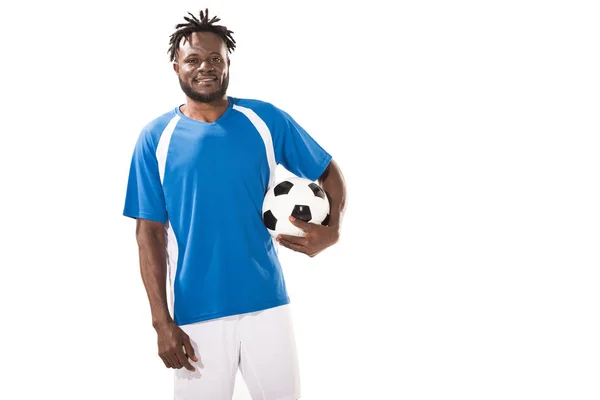 Bel giocatore di calcio afroamericano che tiene palla e sorride alla telecamera isolata sul bianco — Foto stock
