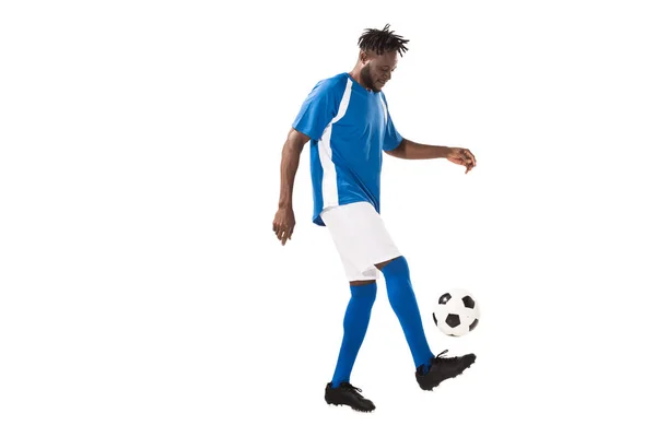 Вид сбоку атлетичного афроамериканца, играющего с футбольным мячом на белом — стоковое фото