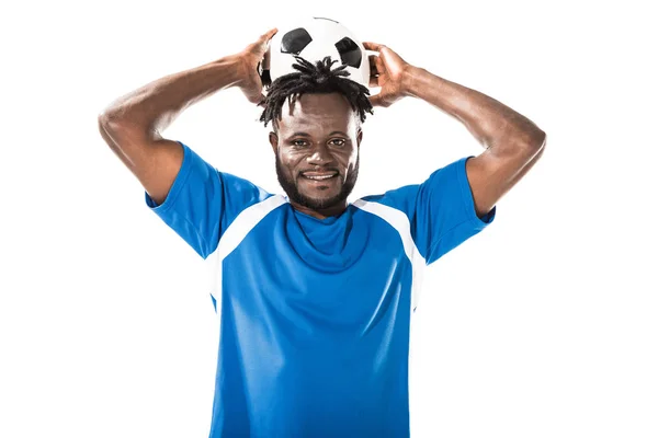 African american sportsman holding soccer ball above head and smiling at camera isolated on white — Stock Photo