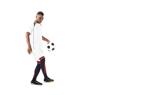 Bello giovane sportivo afro-americano che gioca con pallone da calcio isolato su bianco — Foto stock