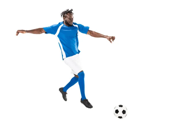 Vue de pleine longueur du footballeur afro-américain athlétique frappant le ballon isolé sur blanc — Photo de stock