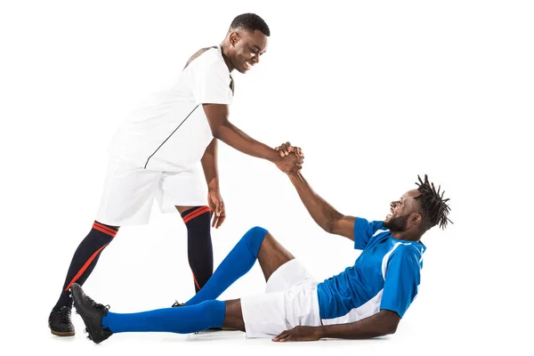 Feliz joven afroamericano deportista ayudando jugador de fútbol aislado en blanco - foto de stock