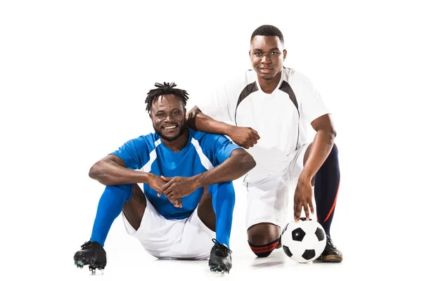 Feliz africano americano futbolistas sonriendo a cámara aislada en blanco - foto de stock