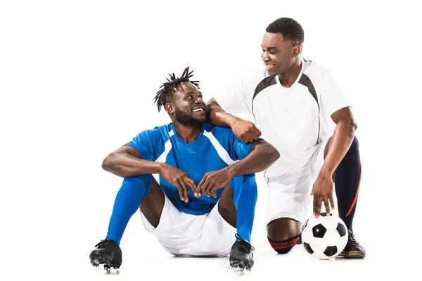 Glückliche afrikanisch-amerikanische Fußballspieler lächeln einander isoliert auf weiß an — Stockfoto