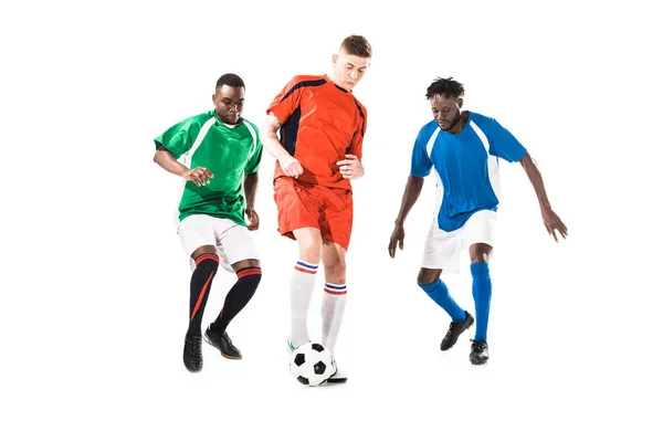 Tre sportivi multietnici che giocano con pallone da calcio isolato su bianco — Foto stock