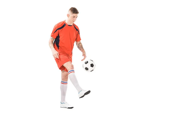 Vue pleine longueur de beau jeune sportif jouant avec le ballon de football isolé sur blanc — Photo de stock