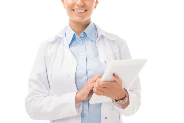 Disparo recortado de la sonriente doctora usando un comprimido aislado en blanco - foto de stock