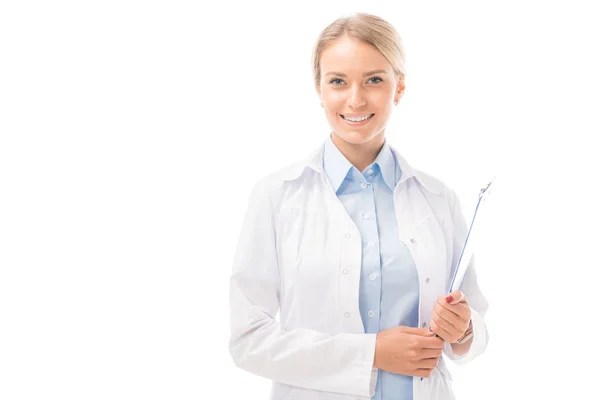 Happy young female doctor with clipboard looking at camera isolated on white — Stock Photo