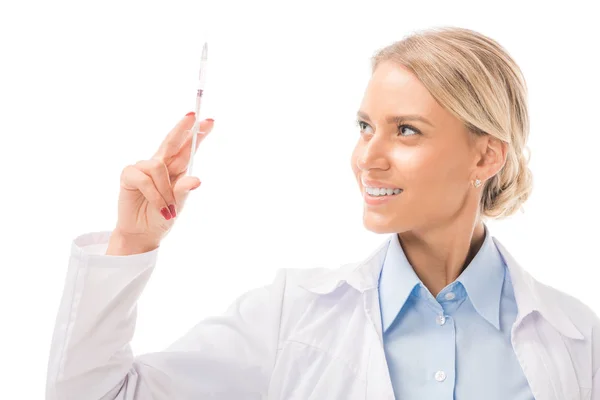 Sonriente joven doctora sosteniendo jeringa aislada en blanco - foto de stock
