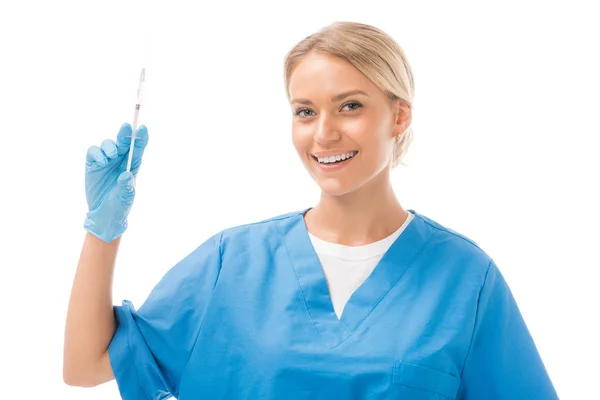 Красива молода медсестра тримає шприц для ін'єкцій і дивиться на камеру ізольовано на білому — стокове фото