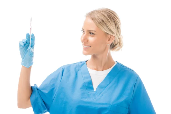 Giovane infermiera sorridente che tiene una siringa per iniezione isolata su bianco — Foto stock