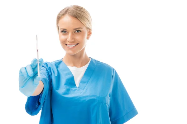 Happy young nurse holding syringe for injection and looking at camera isolated on white — Stock Photo