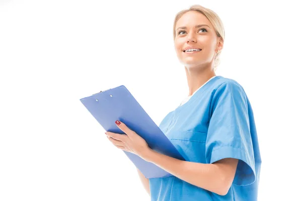 Bottom view of smiling young nurse writing in clipboard isolated on white — Stock Photo