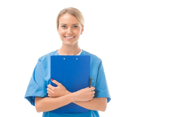 Happy young nurse holding clipboard and looking at camera isolated on white — Stock Photo