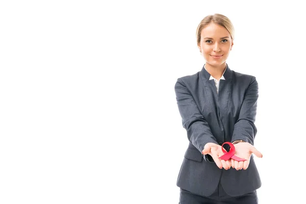 Lächelnde junge Geschäftsfrau mit Hilfsmitteln Bewusstsein rote Schleife Symbol isoliert auf weiß — Stockfoto