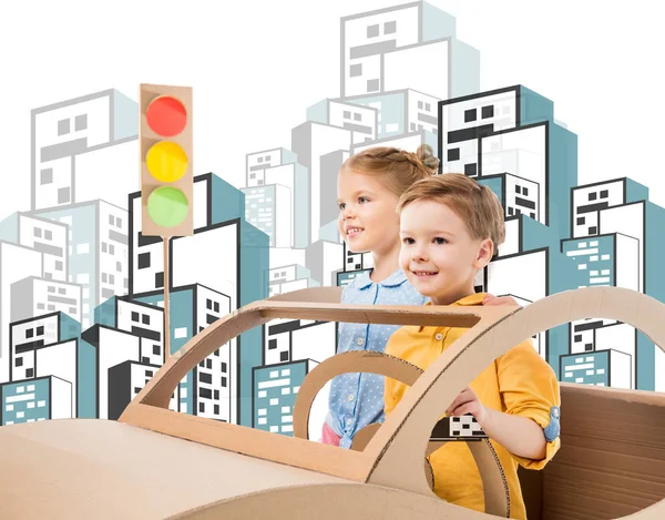 Irmãos felizes brincando com carro de papelão e semáforos na cidade desenhada — Fotografia de Stock