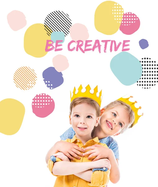 Sister hugging brother, kids in yellow paper crowns, isolated on white with 