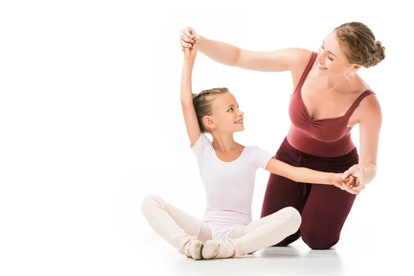 Happy female trainer helping little kid exercising isolated on white background — Stock Photo