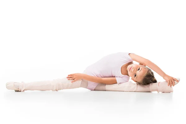 Little ballerina doing twine and stretching isolated on white background — Stock Photo