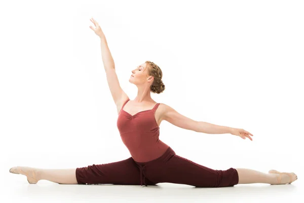 Elegante erwachsene Frau macht Gymnastikübungen, während sie auf Bindfäden auf weißem Hintergrund sitzt — Stockfoto