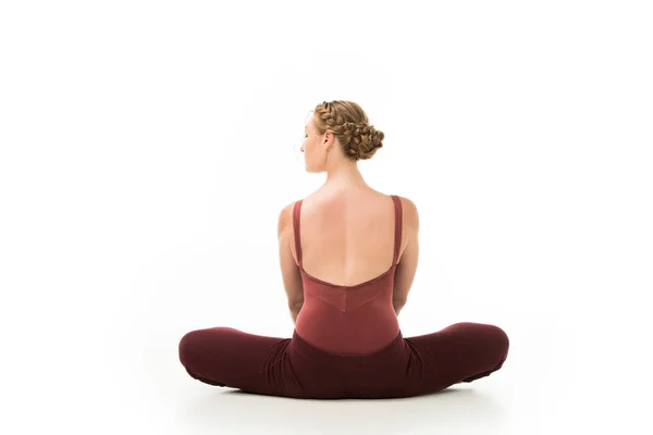 Rear view of elegant ballerina sitting on floor isolated on white background — Stock Photo