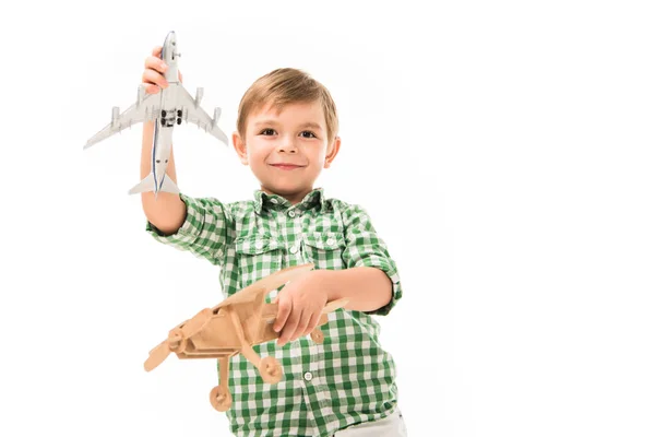 Lächelnder kleiner Junge, der mit Spielzeugflugzeugen auf weißem Hintergrund spielt — Stockfoto