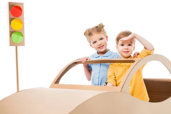 Siblings playing with cardboard car and traffic lights, isolated on white — Stock Photo
