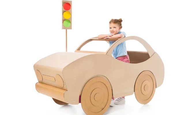 Stylish adorable kid playing with cardboard car and traffic lights on white — Stock Photo