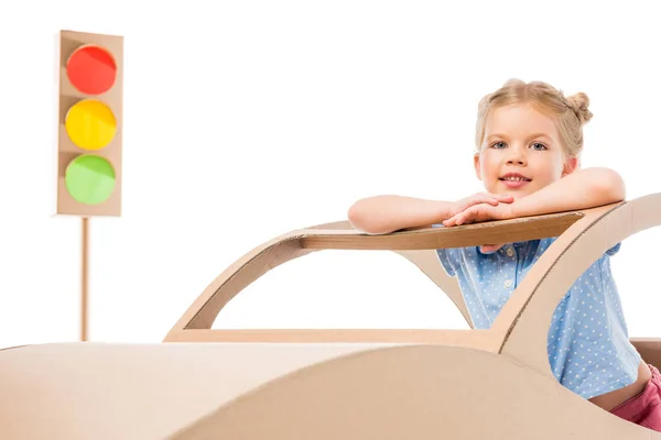 Adorable niño jugando con coche de cartón y semáforos, aislado en blanco - foto de stock