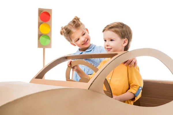 Enfants souriants jouant avec voiture en carton et feux de signalisation, isolés sur blanc — Photo de stock