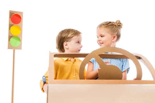 Adorable children driving cardboard car with traffic lights on background, isolated on white — Stock Photo