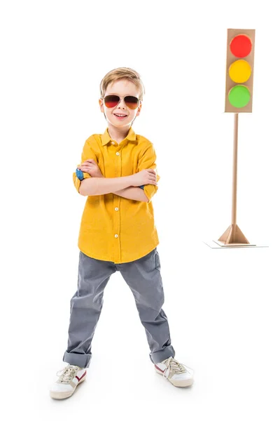 Smiling boy in sunglasses posing with crossed arms, isolated on white with cardboard traffic lights, isolated on white — Stock Photo