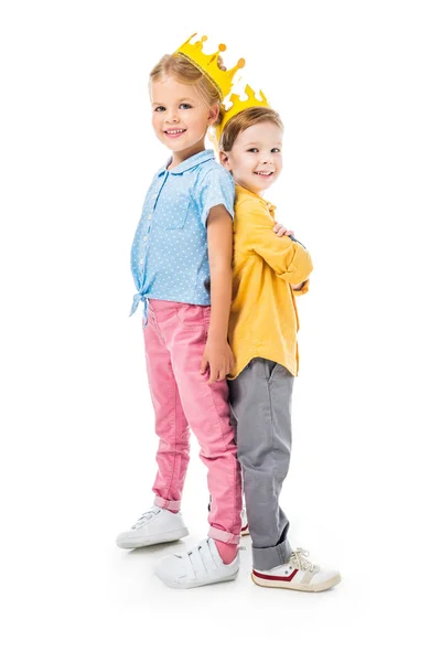 Smiling kids in yellow paper crowns standing back to back, isolated on white — Stock Photo