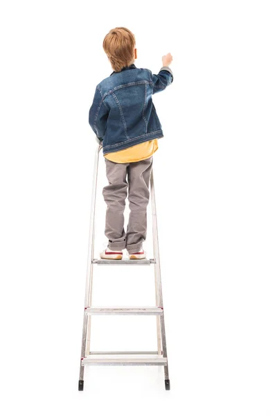 Rear view of pupil standing on ladder and writing isolated on white — Stock Photo