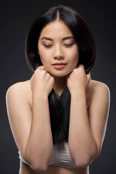 Portrait of pretty asian woman with healthy and strong hair isolated on black — Stock Photo