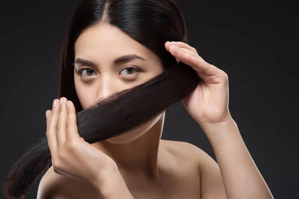 Portrait de jolie asiatique femme avec sain et fort cheveux isolé sur noir — Photo de stock