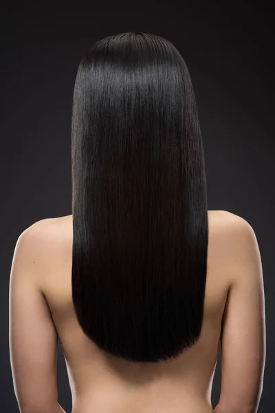 Vista posterior de la mujer con hermoso pelo brillante aislado en negro - foto de stock