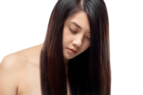 Retrato de modelo asiático atractivo con el pelo fuerte y saludable posando aislado en blanco - foto de stock