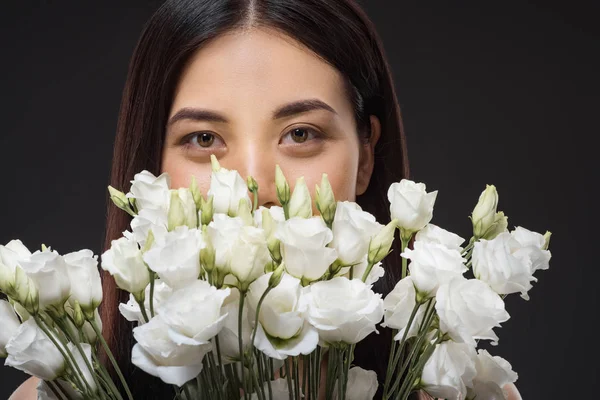 Retrato de mulher asiática com belo cabelo escuro e buquê de flores brancas eustoma isolado em preto — Fotografia de Stock