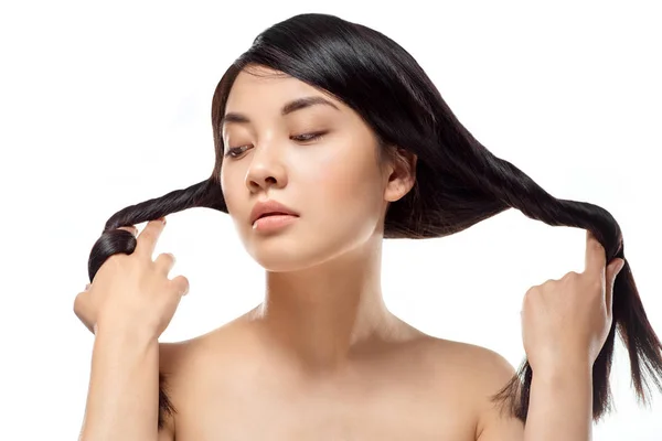 Retrato de modelo asiático atractivo con el pelo fuerte y saludable posando aislado en blanco - foto de stock