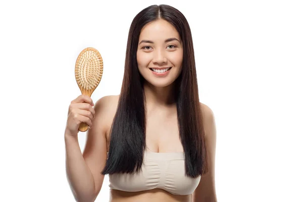 Portrait of smiling beautiful asian woman with hair brush isolated on white — Stock Photo