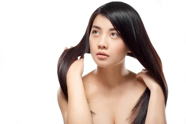 Retrato de modelo asiático atractivo con el pelo fuerte y saludable posando aislado en blanco - foto de stock