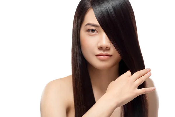 Retrato de modelo asiático atractivo con el pelo fuerte y saludable posando aislado en blanco - foto de stock