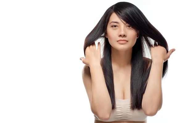 Retrato de modelo asiático con cabello sano y brillante posando aislado sobre blanco - foto de stock