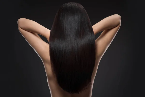 Vue arrière de la femme avec de beaux cheveux brillants isolés sur noir — Photo de stock