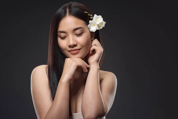 Porträt der schönen jungen asiatischen Frau mit weißen Blumen im Haar isoliert auf schwarz — Stockfoto