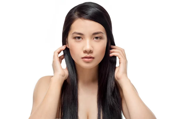 Retrato de joven modelo asiático con cabello sano y brillante mirando a la cámara aislada en blanco - foto de stock