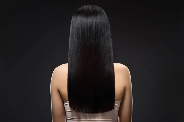 Vista posterior de la mujer con hermoso pelo brillante aislado en negro — Stock Photo